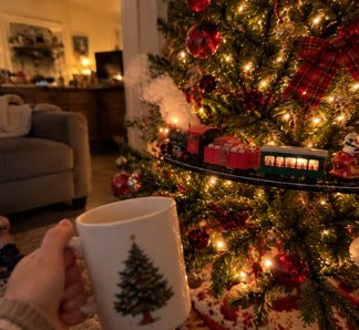 Holiday mug in front of the Emerald Express on the tree