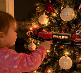 Toddler reaching for the Emerald Express on the tree