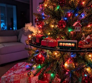 Emerald Express train circling a colourfully lit Christmas tree